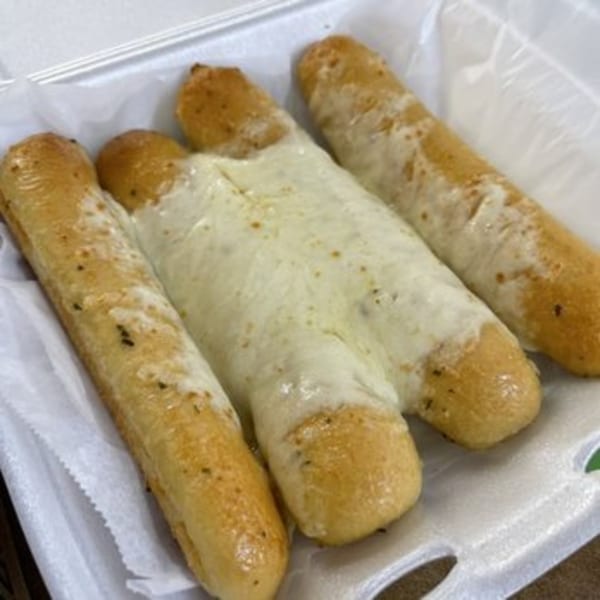 Four golden-brown breadsticks, two plain and two covered in melted mozzarella cheese, in a white container.